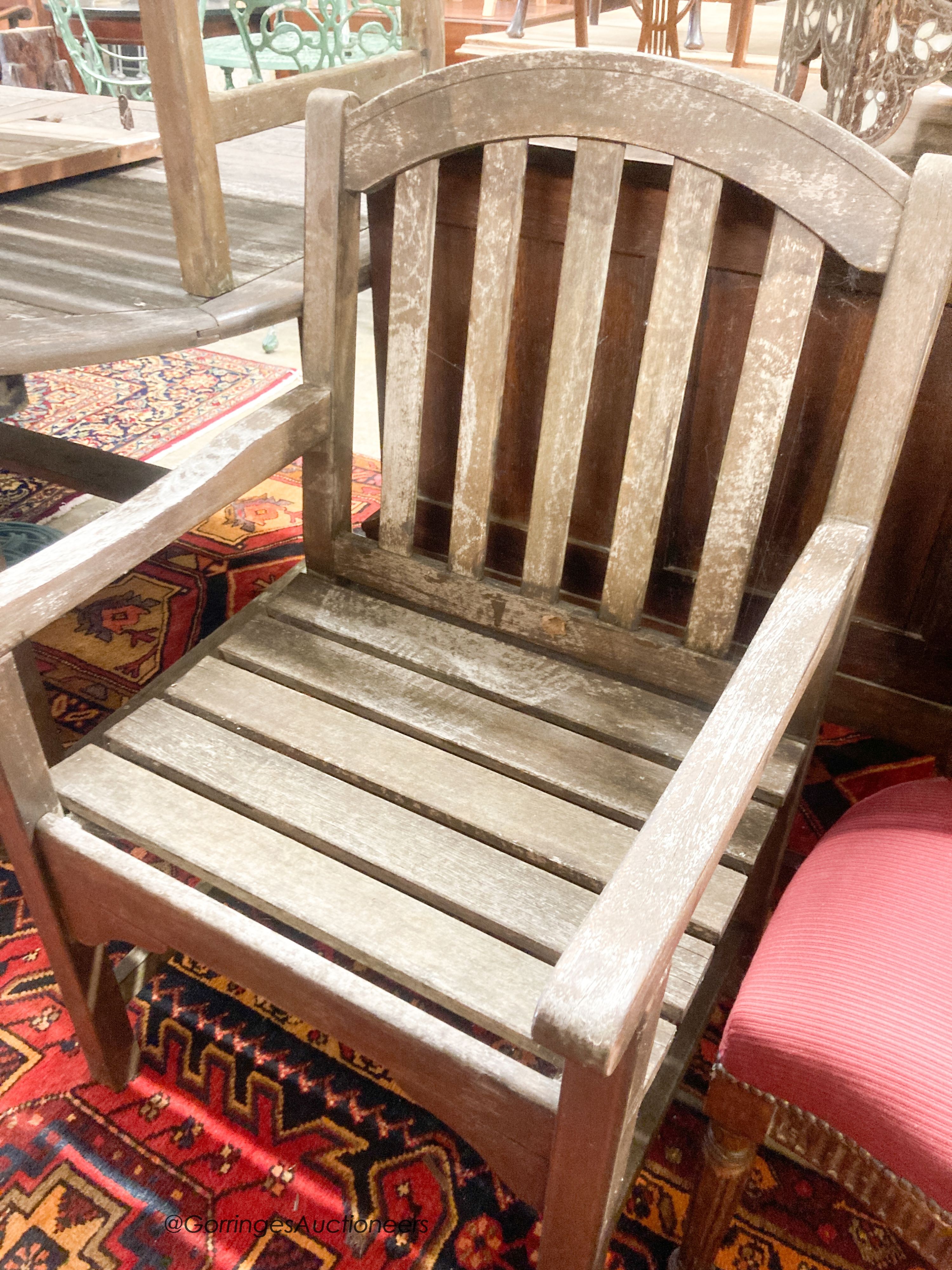 A weathered teak extending garden table, length 190cm, depth 120cm, height 74cm a bench and four weathered teak armchairs